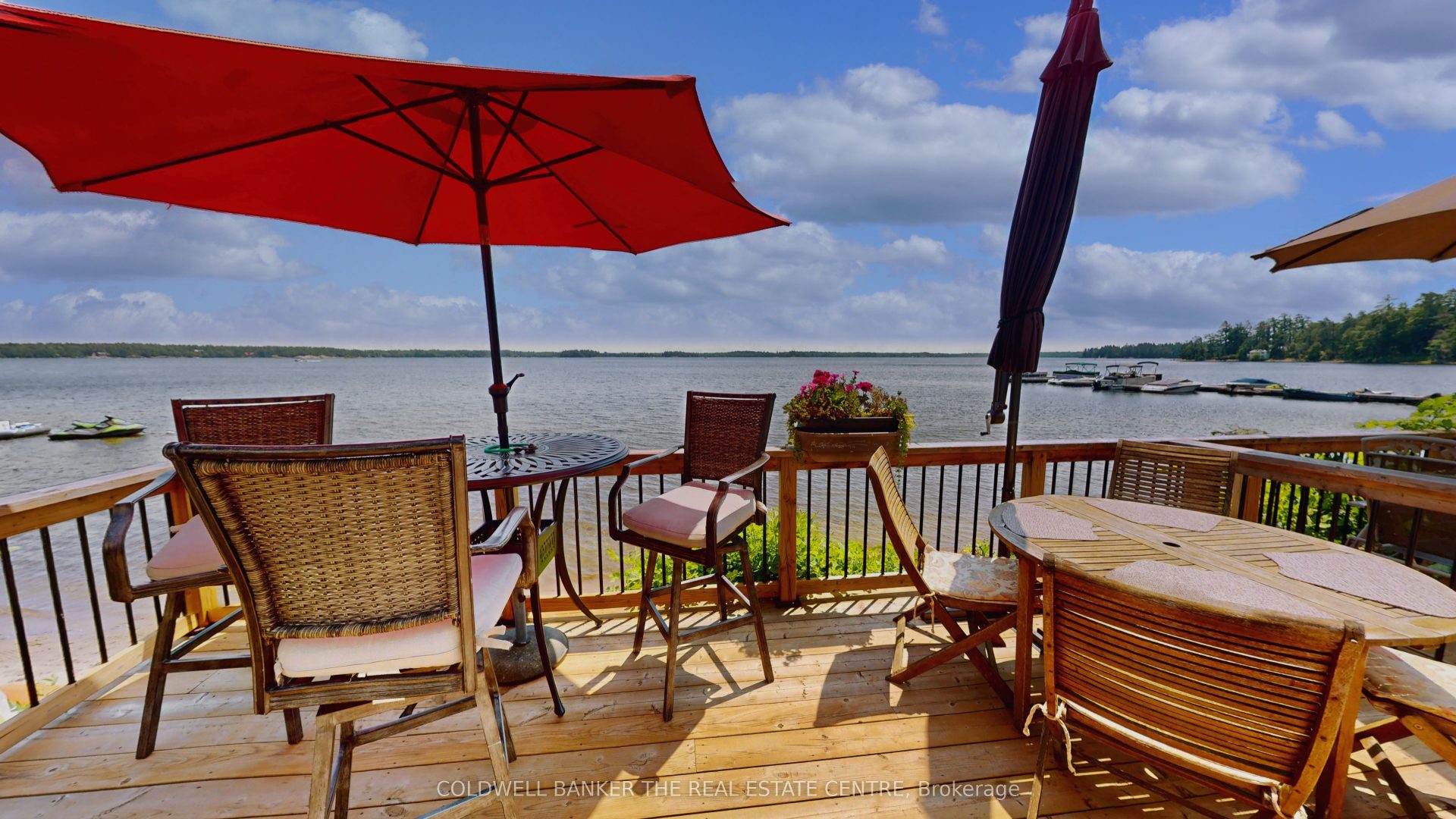 A wood deck with patio seating and a red umbrella