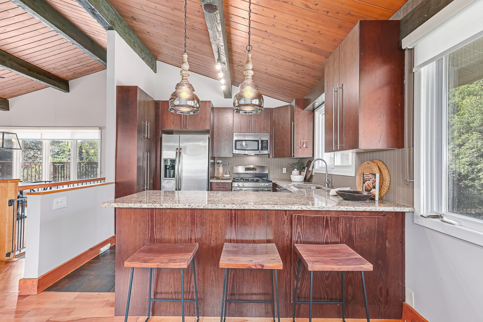A red-brown kitchen with a wood island and wood bar stools
