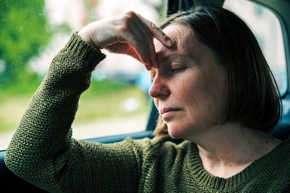A woman experiencing motion sickness in the car