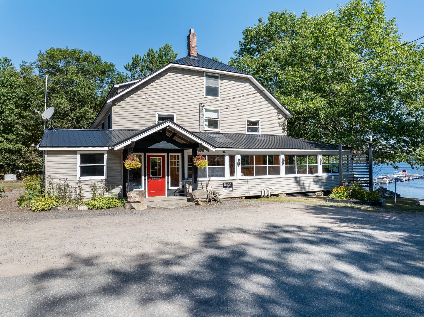 A multi-level clapboard cottage with a red door