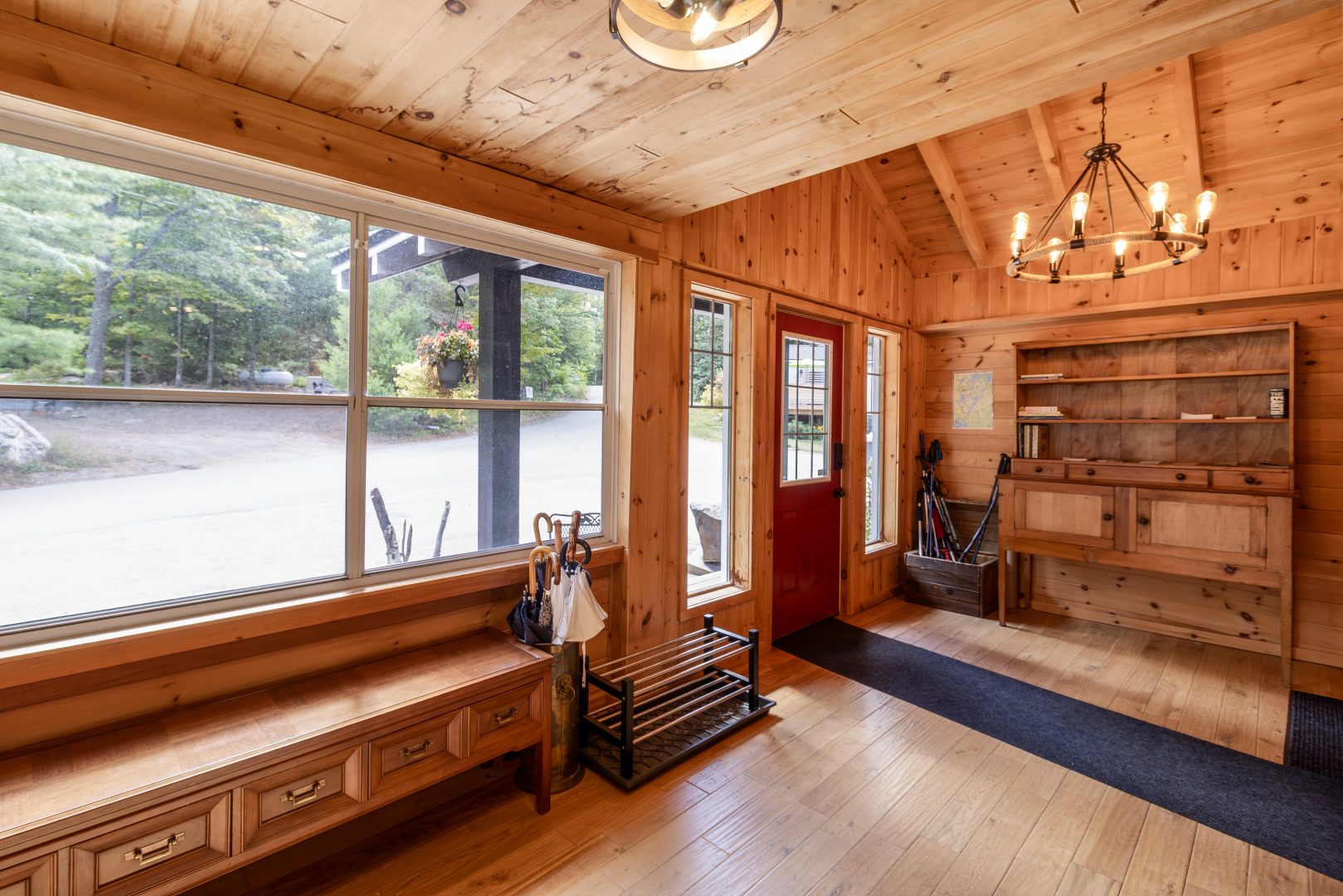 A wood-paneled entryway with bright windows and a runner rug