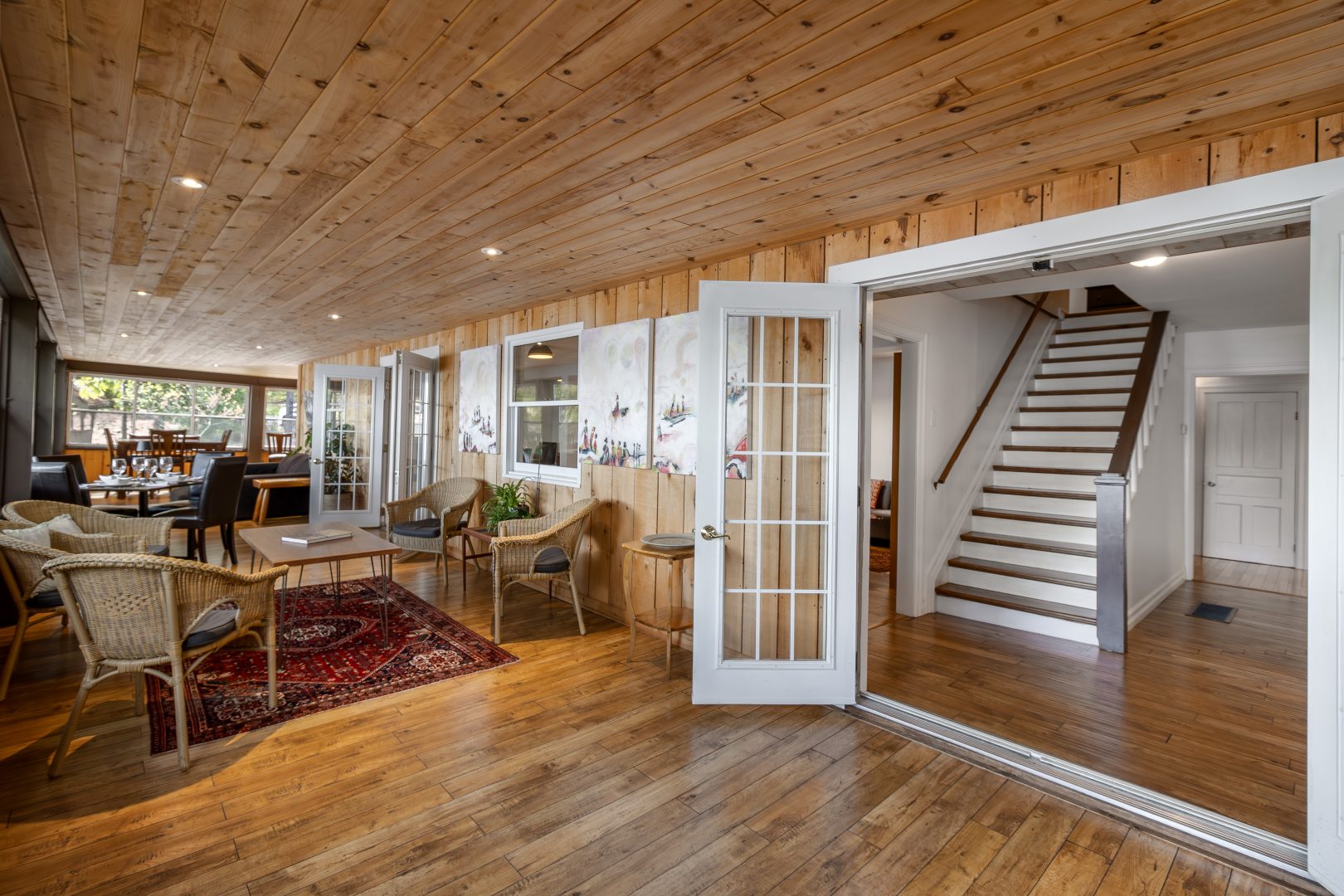 An open-concept sitting area with French doors opening to a stairwell
