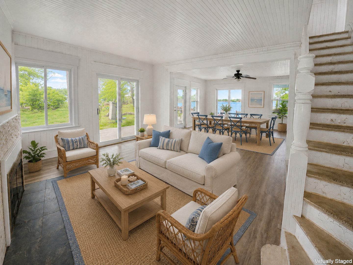 A beige couch faces a stone fireplace in a bright living room