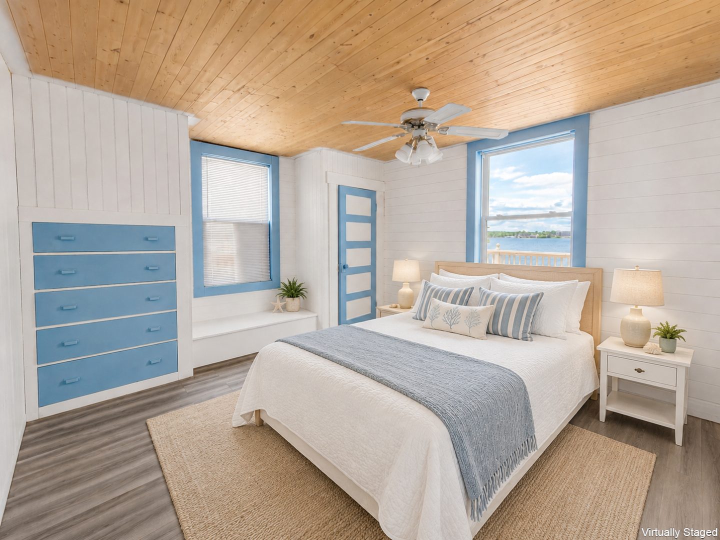 A white bed with a light blue throw blanket in a white bedroom