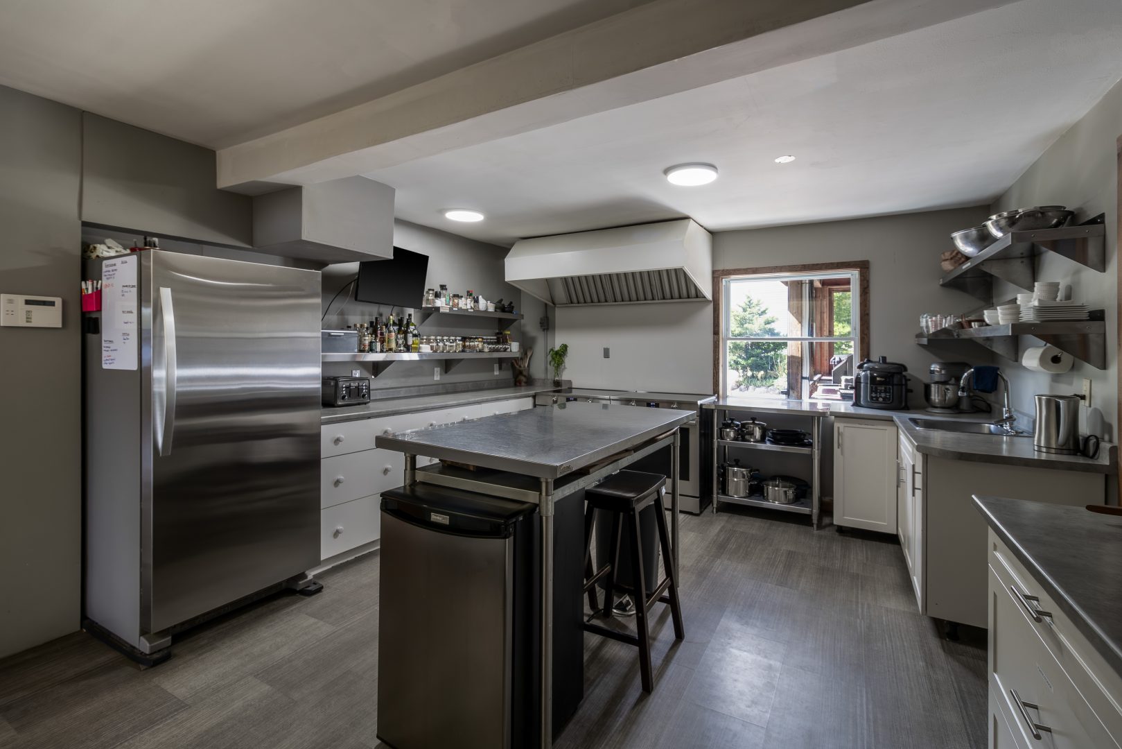 A grey kitchen with a large island and stainless steel appliances