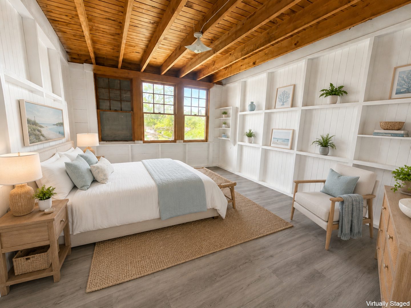A white bed with a blue throw blanket in a white bedroom with exposed wood beams