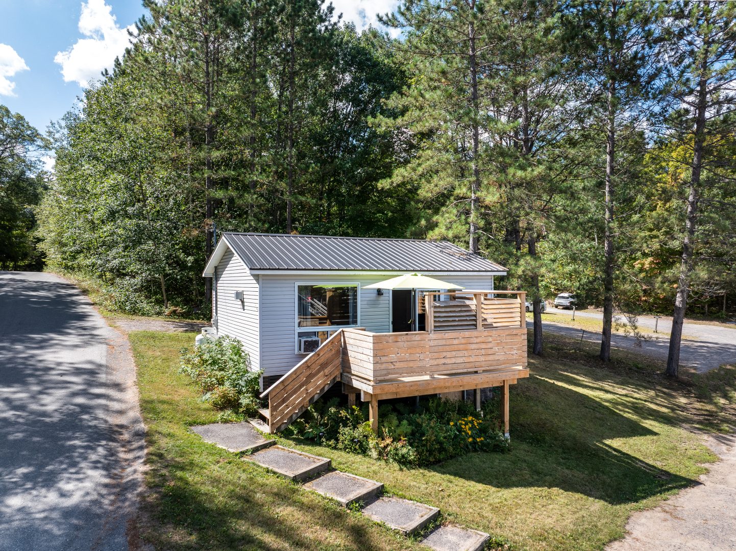 A small white clapboard cottage with wood steps