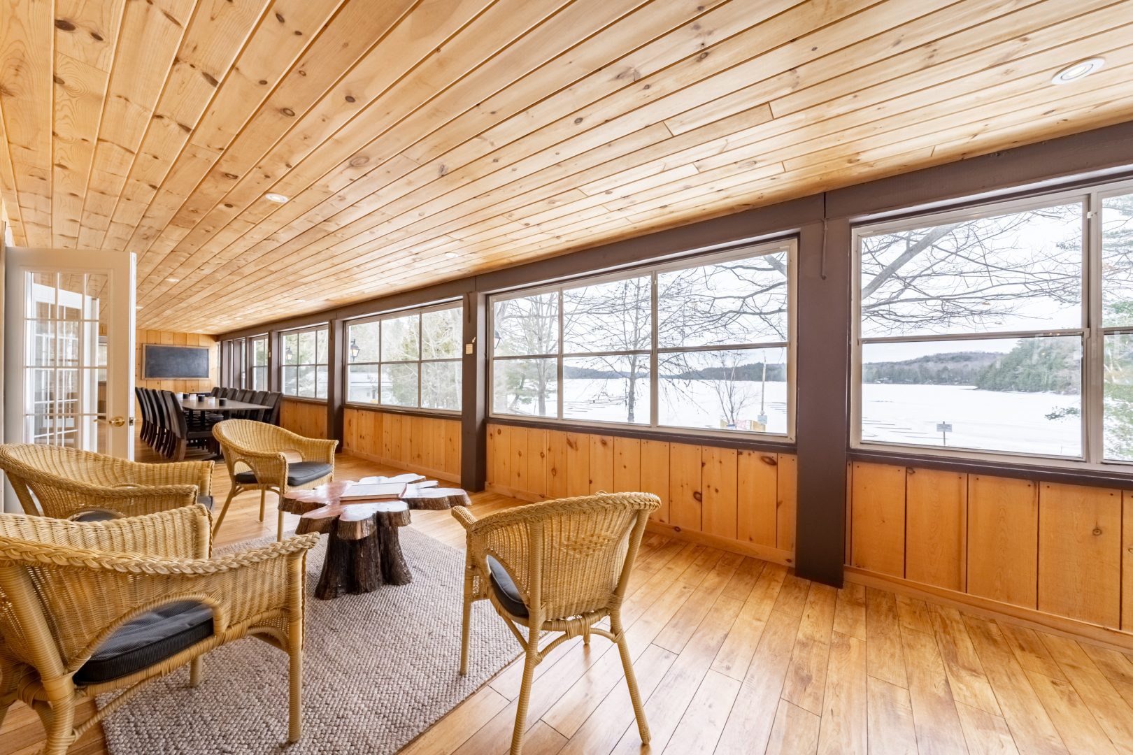 A sitting area facing a wood-framed wall of windows