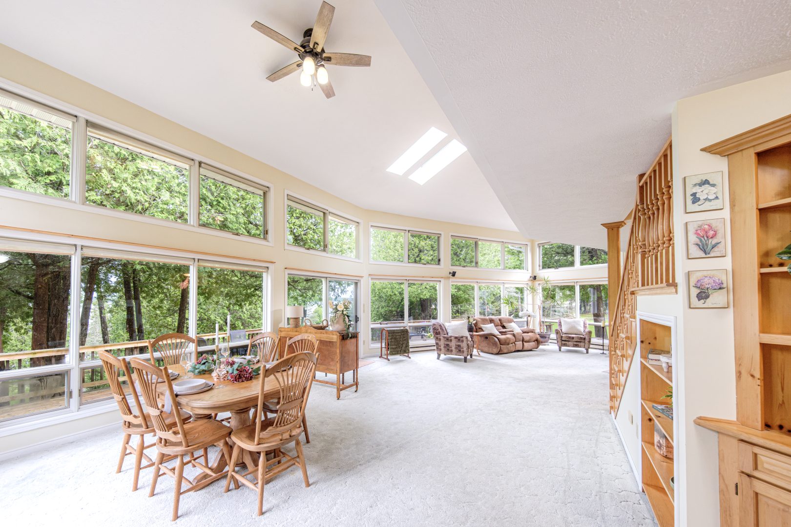 A spacious living room with a wood dining table and a sitting area