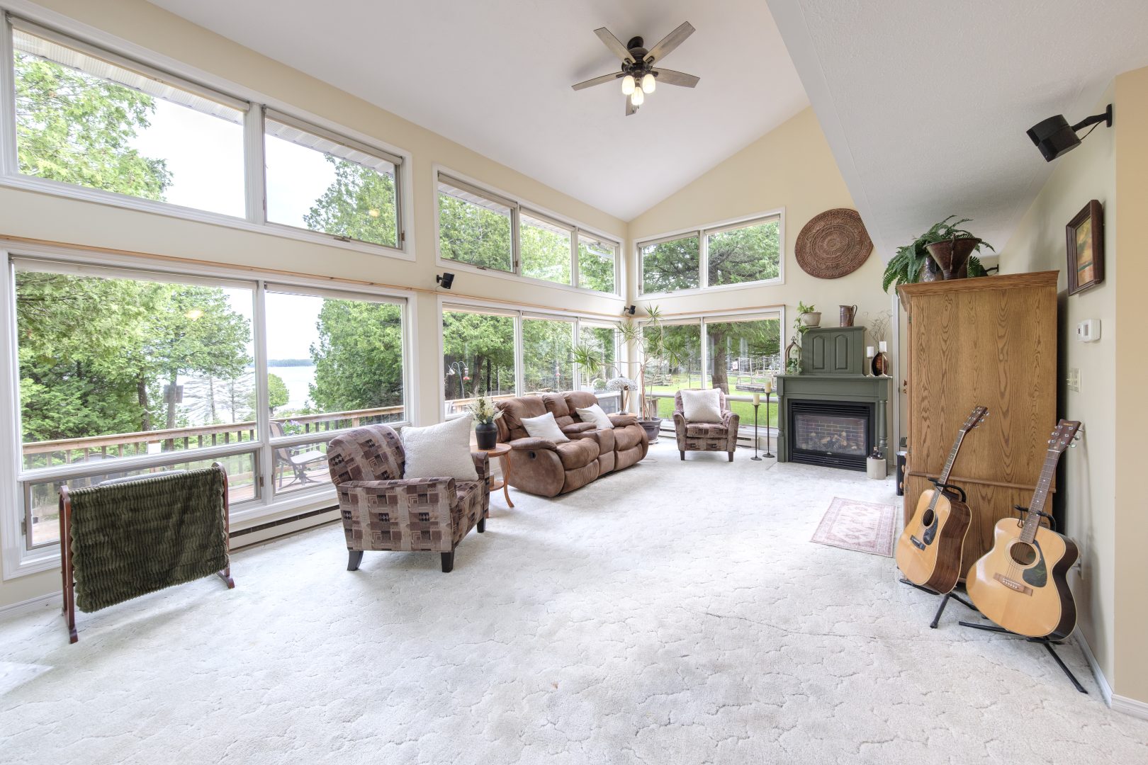 A spacious living room with floor-to-ceiling windows and multiple sitting areas