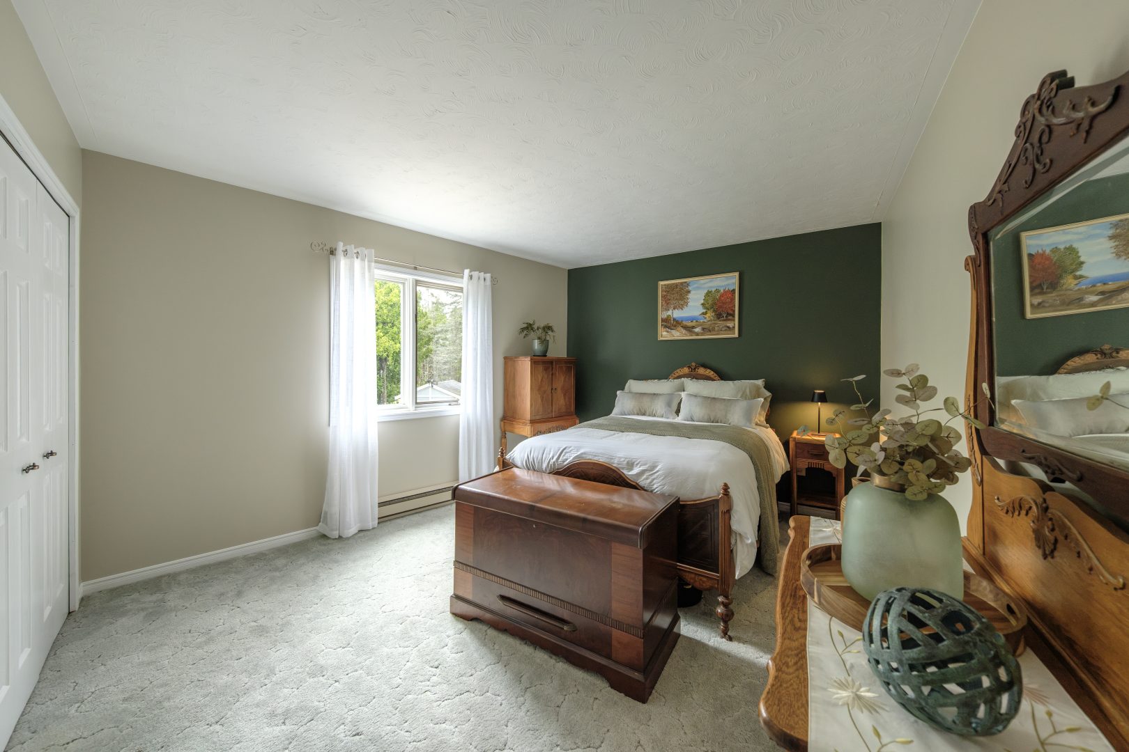 A white bed in a beige and green room