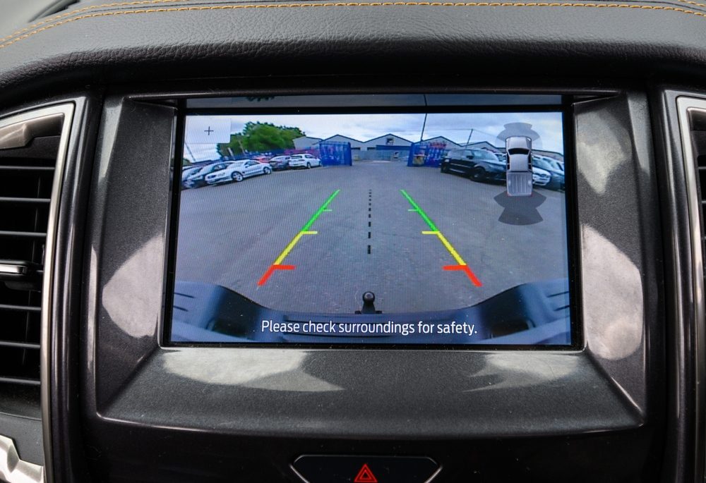 Modern cars infotainment screen displaying a live feed from the backup reverse camera, assisting the driver with safe parking and obstacle detection