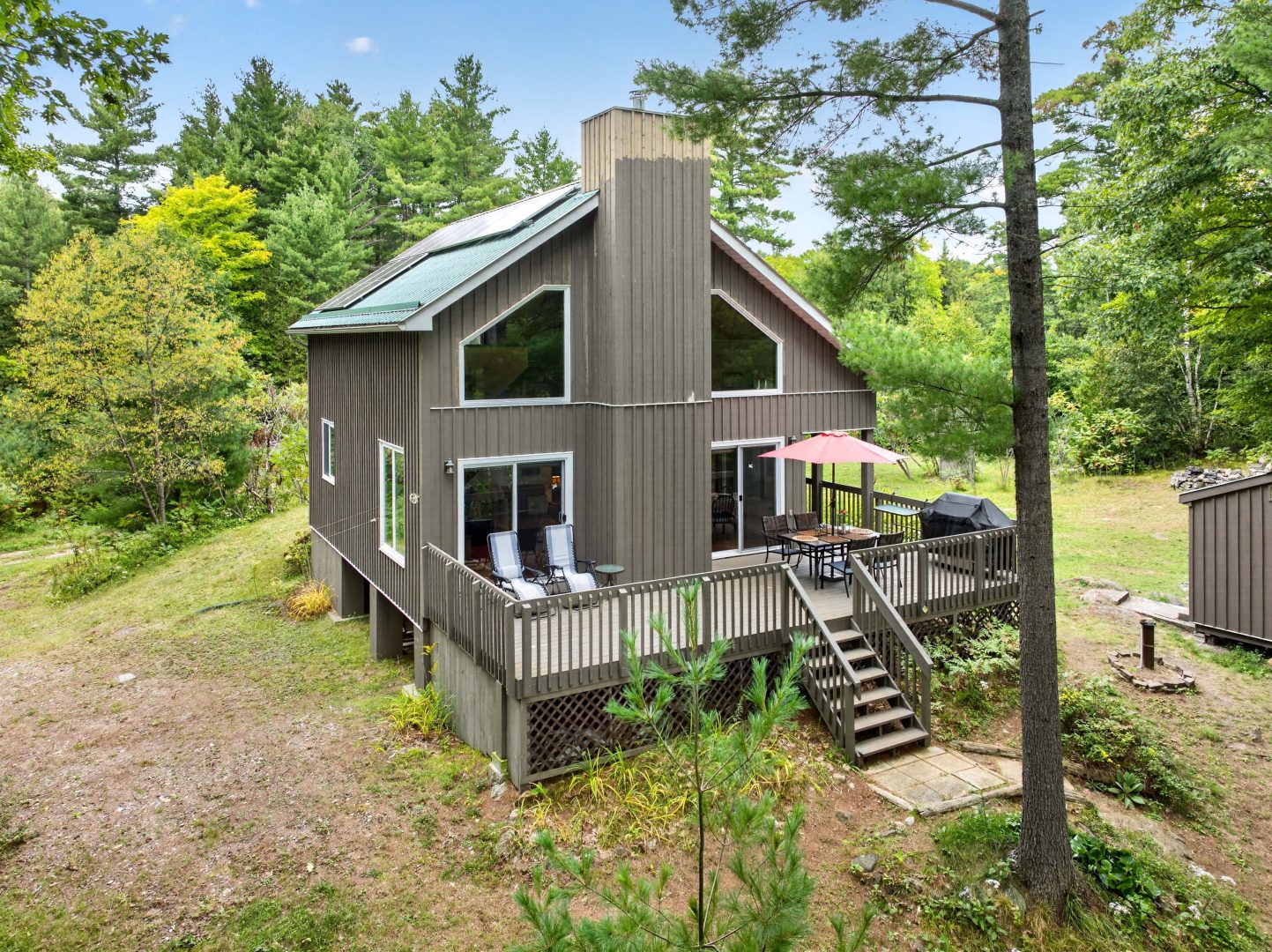 A two-story clapboard cottage with a large deck