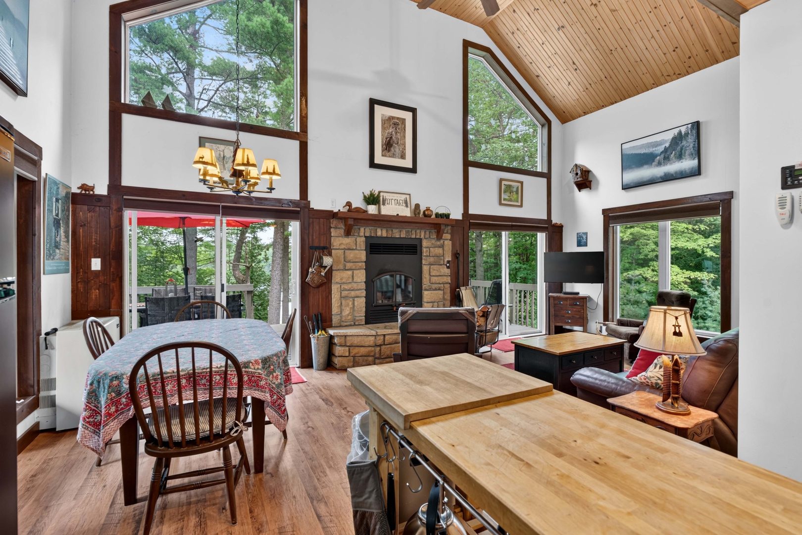 A long wood table in a living room with a stone fireplace