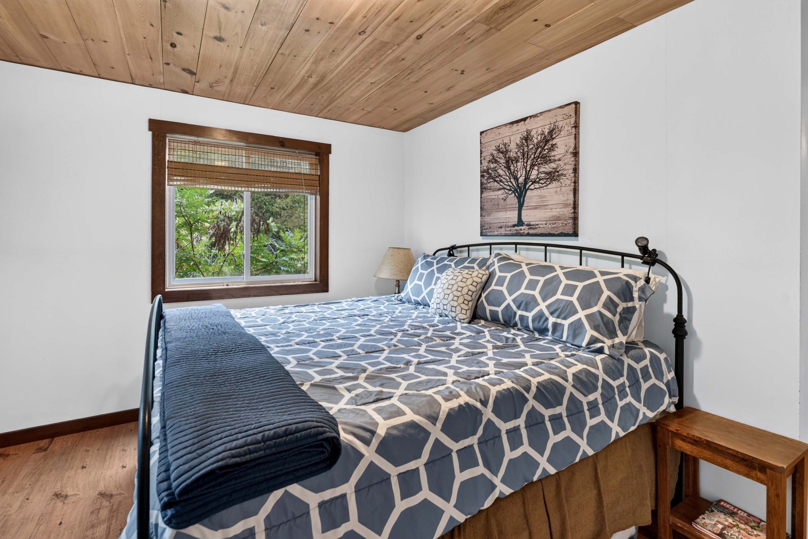 A grey bed in a white bedroom