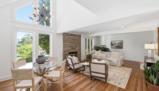 A sitting area with beige couches in front of a stone fireplace