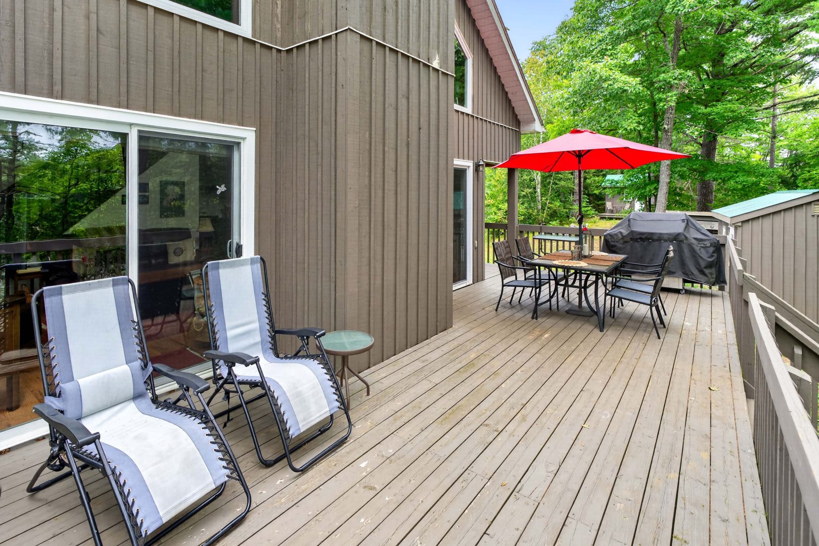 A light brown deck with a small outdoor seating area