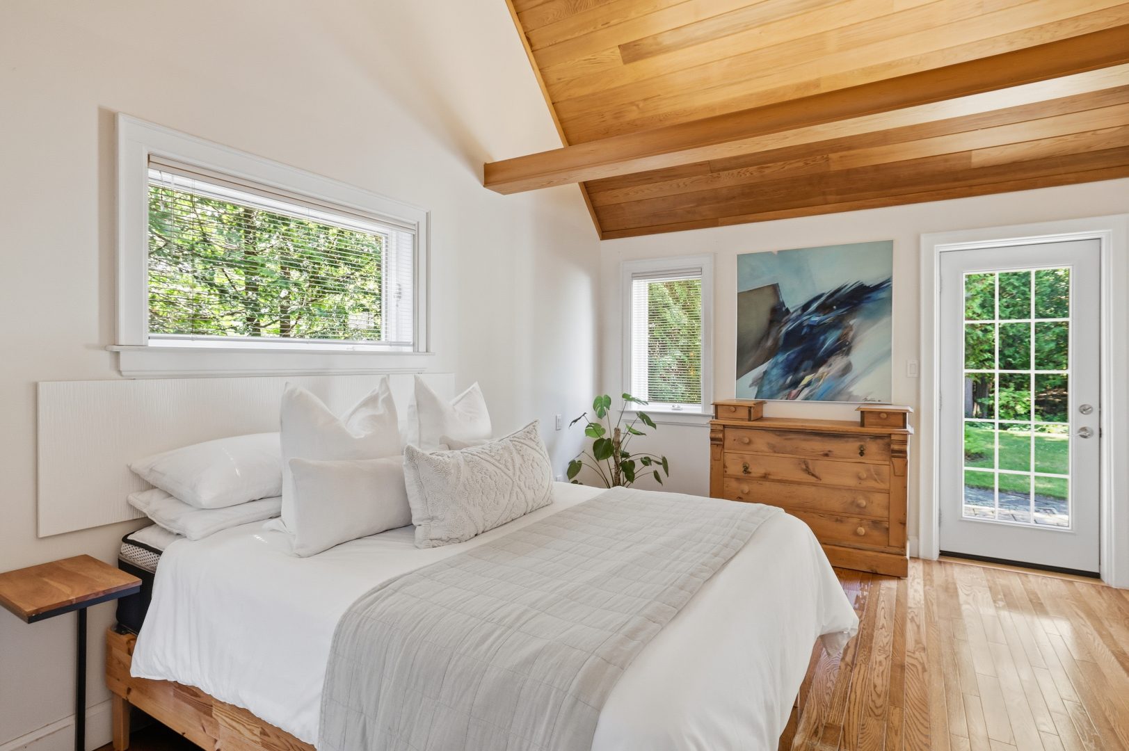 A white bedroom with wood vaulted ceilings