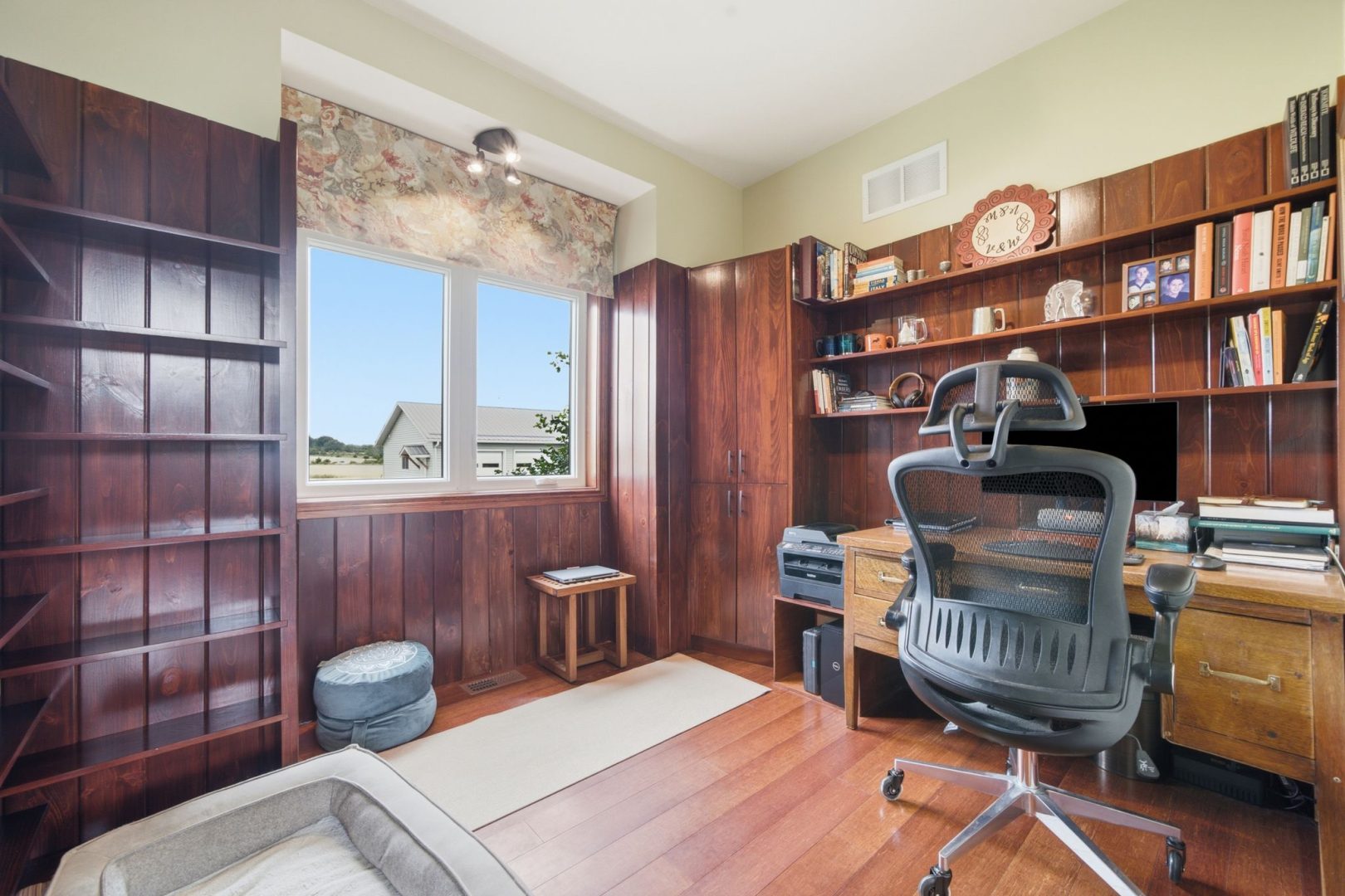 A dark wood office with built-in shelves