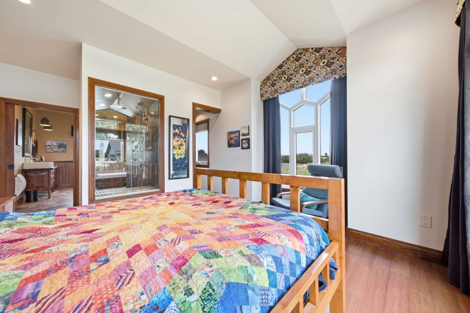 A colourful bed faces an ornate window