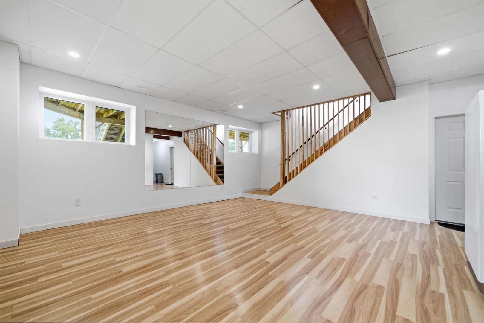 An empty white room with hardwood floors