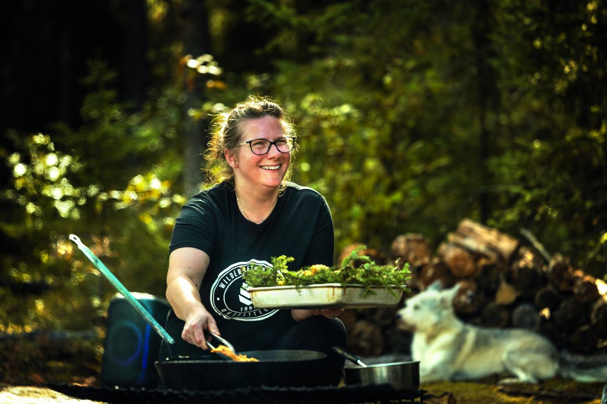 A chef cooking fish over a campfire