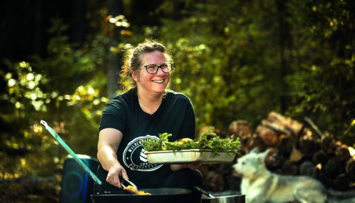 A chef cooking fish over a campfire